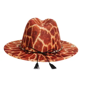Detail of giraffe print wool fedora featuring gold chain and black tassel accents
