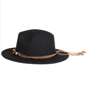 Detailed view of bohemian style brown beaded tassels on a black wool jazz hat