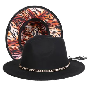 Detail of fedora hat with metal chain decoration and orange tiger print lining