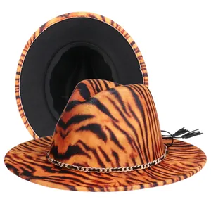 Detail view of orange tiger print fedora hat with gold chain and black tassel accent