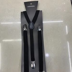 Close-up of black Y-back suspenders with silver metal clips on cardboard packaging