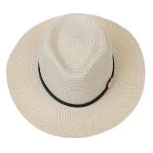 Close-up of beige straw jazz hat featuring a black rope band and small wooden heart charm