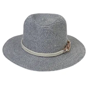 Detail of navy and white woven straw sun hat with decorative rope and gold chain