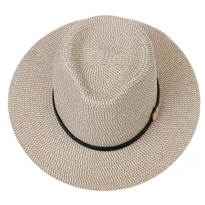 Detail of woven straw fedora hat featuring a brown rope band and a light wooden button