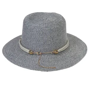 Detail of blue and white striped straw hat weave with decorative rope and gold chain