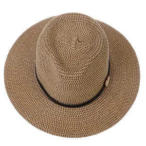 Close-up of woven straw hat texture with black cord and circular wooden accessory detail
