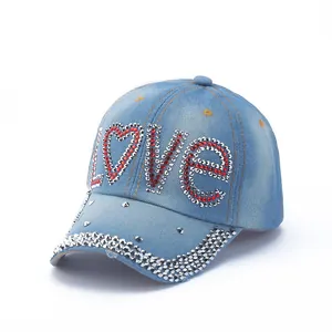 Detail of the LOVE rhinestone and silver stud embellishments on blue denim baseball cap