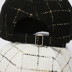 Detail of adjustable metal buckle on tweed plaid baseball cap with glitter thread