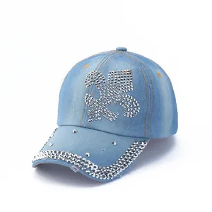 Detailed view of light blue denim baseball cap with rhinestone fleur-de-lis and silver studs