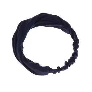 Dettaglio della fascia per capelli yoga blu scuro con nodo a torsione e tessuto elastico