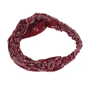 Détail macro du bandeau de yoga paisley rouge foncé avec nœud torsadé et élastique