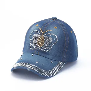 Close-up of rhinestone butterfly on denim baseball cap with crystal studded brim