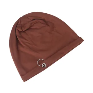 Detailed shot of brown knit beanie featuring decorative silver metal rings on the side