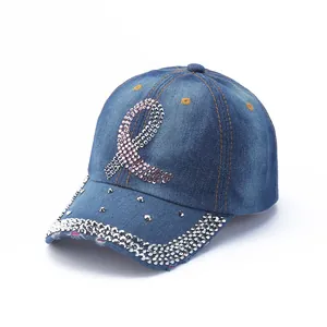 Detailed close-up of washed denim baseball cap featuring pink rhinestones and silver studs