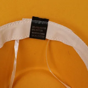 Détail intérieur d'un chapeau en feutre jaune montrant le bandeau et l'étiquette
