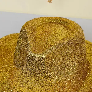 Détail de près des paillettes dorées sur un chapeau fedora jazz métallique