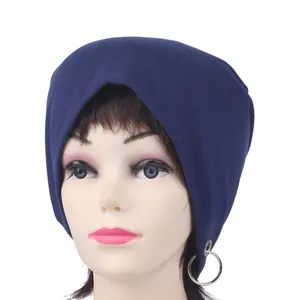 Close-up of a navy blue knit beanie featuring a silver metal ring detail on the side