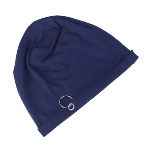 Close-up of a navy blue knit beanie featuring a decorative silver metal ring detail