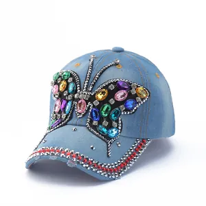 Close-up of a blue denim baseball cap featuring a large colorful rhinestone butterfly detail