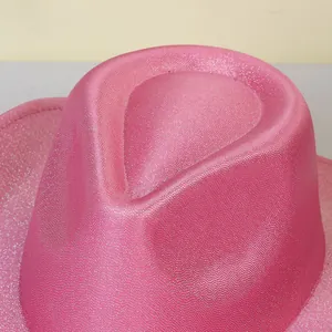 Macro detail of sparkly pink cowboy hat showing sequined texture and top crown indentation
