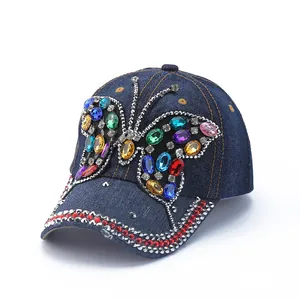 Navy denim baseball cap with a colorful rhinestone butterfly and metal stud accents