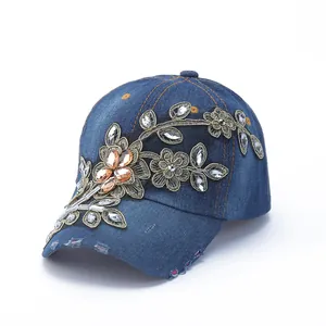 Detailed embroidery and rhinestone accents on a vintage blue denim baseball cap