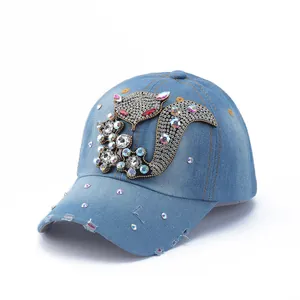 Detail of distressed denim baseball cap with rhinestone squirrel motif and frayed brim edge