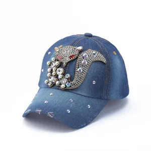 Close-up of sparkling rhinestone fox pattern on distressed blue denim baseball cap