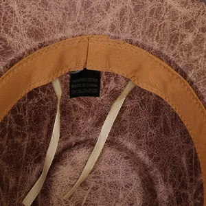 Macro detail of faux leather cowboy hat interior featuring sweatband and 100% polyester tag