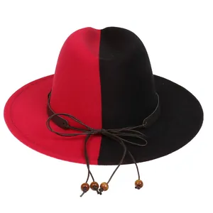 Détail d'un chapeau fedora bicolore rouge et noir avec ruban en cuir et perles bois