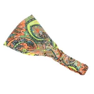 Détail du bandeau de yoga large montrant des motifs paisley orange et vert vifs