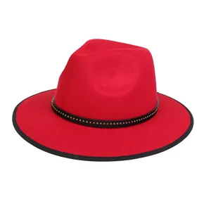 Dettaglio cappello fedora rosso con fascia in pelle nera e borchie dorate lucide