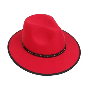 Dettaglio cappello fedora rosso con fascia nera a rivetti e borchie dorate in feltro