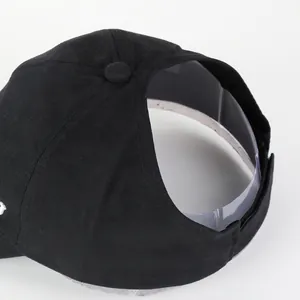 Detail of ponytail hole and double stitching on black sun visor hat with back opening