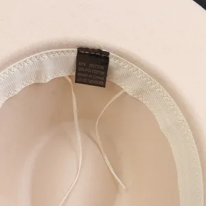 Dettaglio dell'interno del cappello in feltro con fascia tergisudore ed etichetta di lavaggio