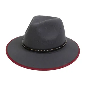 Dettaglio di cappello in lana con cinturino in pelle borchiato e bordo rosso a contrasto