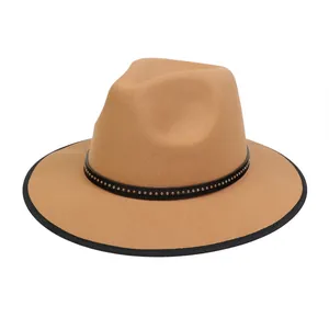 Dettaglio cappello fedora in lana cammello con fascia nera a borchie su sfondo bianco