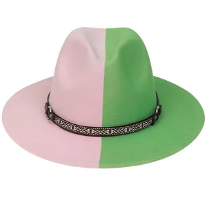 Détail d'un chapeau fedora bicolore rose et vert avec ruban décoratif à motif ethnique