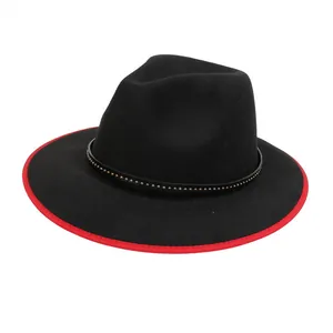 Dettaglio cappello fedora nero con bordo rosso a contrasto e fascia in pelle borchiata