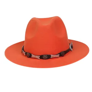 Detail eines orangen Wollhutes mit schwarzem Lederband und silbernen Metallverzierungen