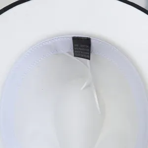 Dettaglio dell'interno del cappello jazz bianco con bordo nero ed etichetta tessile