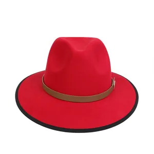 Dettaglio cappello fedora rosso con bordo profilato nero e fascia decorativa in cuoio