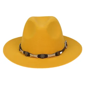 Nahaufnahme gelber Fedora-Hut mit schwarzem Lederband und bronzenen Sternnieten