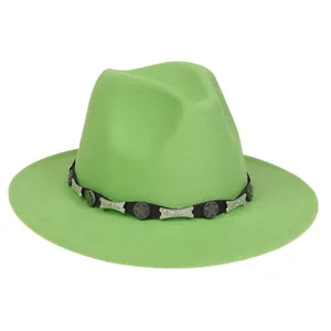 Detail eines grünen Fedora-Hutes mit Lederband und silbernen Sternnieten im Western-Stil