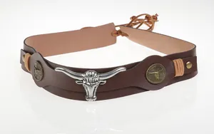 Detail of a brown leather cowboy belt with a silver bull head and antique bronze studs