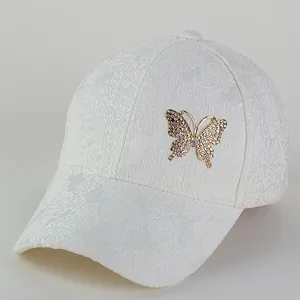 Elegant white lace baseball cap featuring an ornate gold butterfly with colorful rhinestones