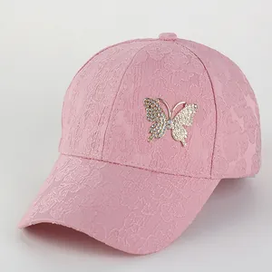 Detailed view of pink floral lace baseball cap with a sparkling gold butterfly brooch