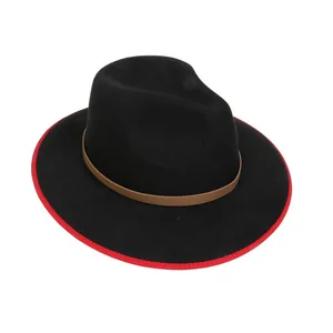 Dettaglio cappello fedora nero con bordo rosso e fascia in pelle marrone