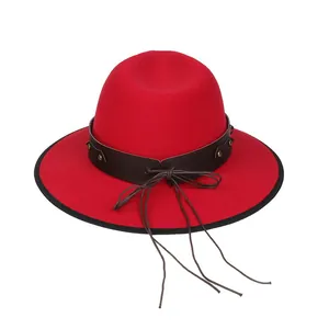 Dettaglio cappello fedora in lana rossa con fascia in pelle, borchie e lunghe nappe