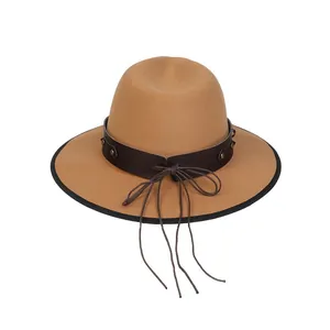 Dettaglio del cappello fedora in lana cammello con fascia in pelle e rivetti vintage
